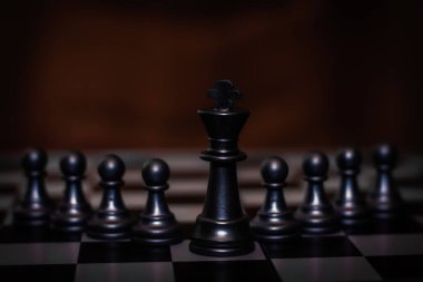 Kral satranç taşı piyon önünde durmak (Liderlik kavramı, yönetim)