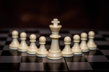 Kral satranç taşı piyon önünde durmak (Liderlik kavramı, yönetim)