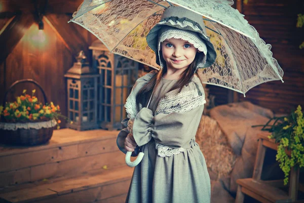 Retrato de uma menina bonita em um vestido vintage com um guarda-chuva. Imagem retrô. Estilo de arte — Fotografia de Stock