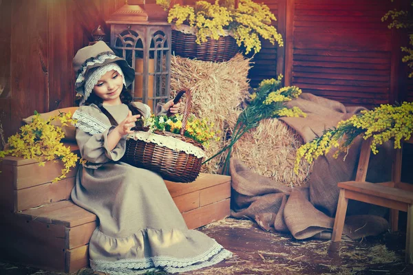 Belle fille en robe rétro avec un panier de fleurs sur un fond de paille. Style rétro. Carte de Pâques . — Photo