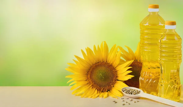 Sunflower oil in bottles, seeds and flowers of sunflower close up with copy space for text