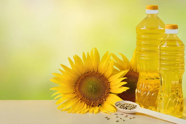 Sunflower oil in bottles, seeds and flowers of sunflower close up with copy space for text