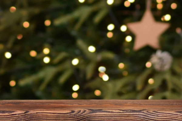 Noel arkaplanı. Noel ağacı ve yılbaşı ağacının arka planında boş ahşap masa. Ürün montajı için hazır.