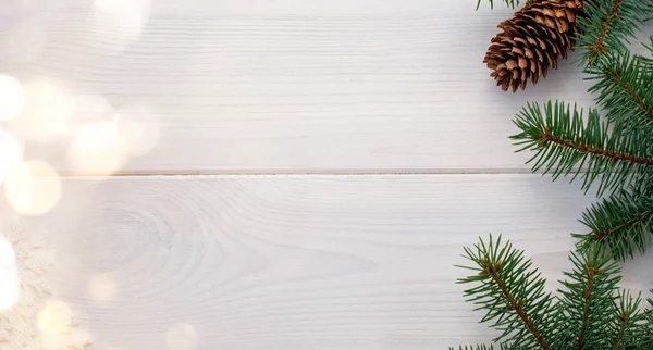 Çam kozalaklı ve kar taneli Noel ağacı beyaz tahta bir tahta üzerine bokeh ve metin için yer kopyalama. Banner. Düz yatıyordu.