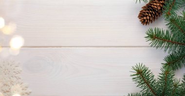 Çam kozalaklı ve kar taneli Noel ağacı beyaz tahta bir tahta üzerine bokeh ve metin için yer kopyalama. Banner. Düz yatıyordu.