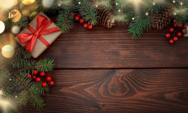 Елка, подарок, шишки, красные ягоды, снег на деревянном коричневом фоне. Плоский лежал