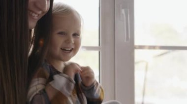 Anne ve küçük kızı yeni yıl kutlamaları için ışıltılı bir gülümsemeyle oynuyorlar, bayram sezonundan mutlular. Noel tatili ve aile birlikte..