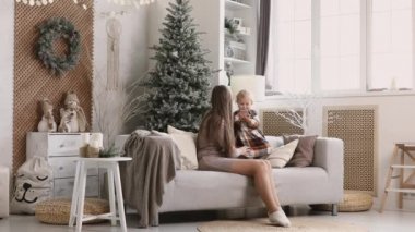 Anne ve kızı telefon eder, video aracılığıyla iletişim kurar, Noel sabahı akıllı telefon kullanır. Küçük kızıyla birlikte genç anne Noel ağacının yanında akrabalarının selamlarını kabul ediyor..