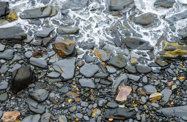 スペインのアストゥリアン海岸の沈黙のビーチの水で濡れた黒い石 — ストック写真