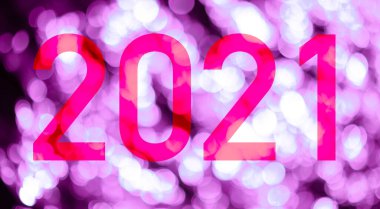 Üzerinde 2021 yılının numarası olan pembe tonlu parlak ışıkların arkaplanı olan metin. Mutlu yıllar 2021.