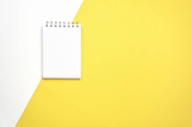 beyaz ekran not defteri boş pastel Sarı zemin üzerine yerleştirilir. Reklam için kullanılan grafik için uygundur..