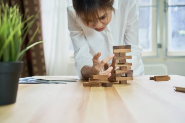 kadın ve bir piramit boş tahta küpleri ile yapım çalışması. İş kavramı ile bir firma olarak için adım adım.