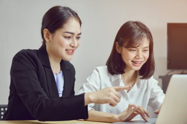 İş kadınları ofiste çalışmak için dizüstü bilgisayarlar ve akıllı telefonlar kullanıyorsunuz. Müşteri hizmet dış kaynak.