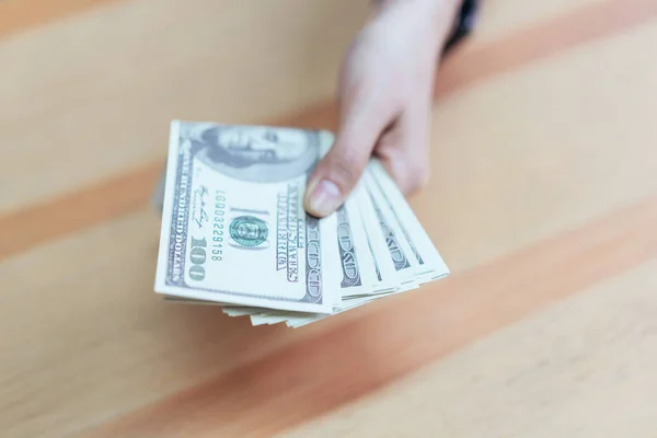 Women holding and give dollar money in the office. The concept of spending by cash.