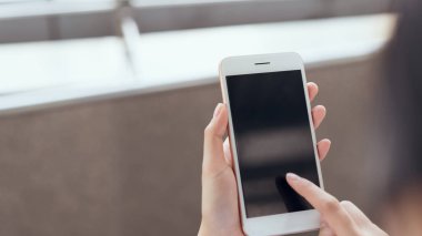 Boş zamanlarında kamusal alanlarda akıllı telefon kullanan bir kadın. Telefonu kullanma konsepti günlük hayatta gereklidir..