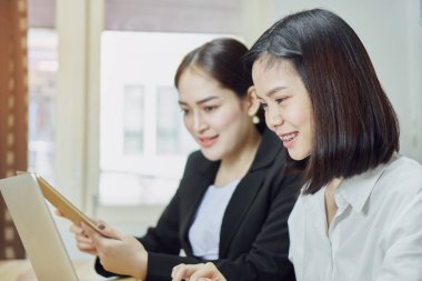 İş kadınları ofiste çalışmak için dizüstü bilgisayarlar ve akıllı telefonlar kullanıyorsunuz. Müşteri hizmet dış kaynak.