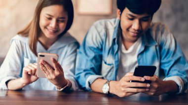 Arkadaşlar smartphone üzerinde kafe, serbest zaman sırasında kullanarak. Telefonu kullanarak kavramı günlük yaşamda esastır.