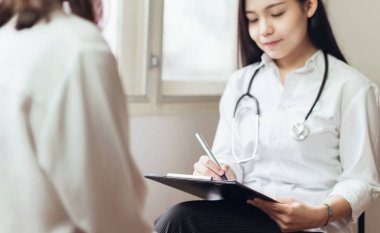 Doktor hasta ile istişare sağlar ve tedavi geçmişini iyice kaydeder. Sağlık ve profesyonellik anlayışı.