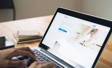Bangkok, Tayland - 12 Mart 2019: kadın kullanmak laptop ekran Paypal web sayfalarını gösteren tablo. Internet üzerinden para transferi popüler ve uluslararası yöntemidir.