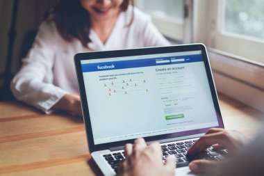 Bangkok, Tayland - 20 Mart 2019: Kadınlar apple macbook pro giriş ekranı Facebook simgeleri kullanın. dünyanın en büyük ve en popüler sosyal ağ sitesi.