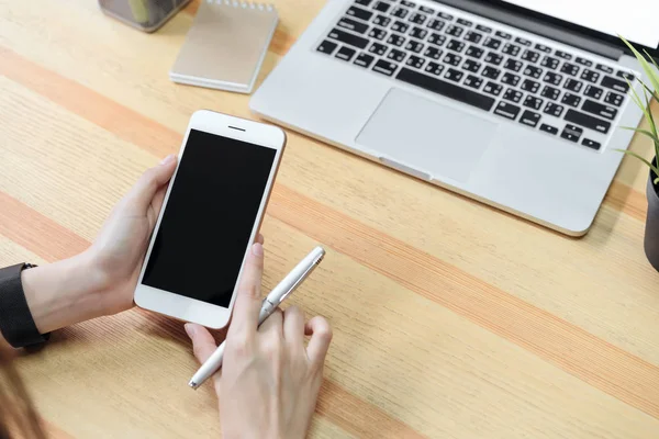 woman holding a blank screen phone and a laptop  and put a smart watch, film effect. Concept technology and modernization.