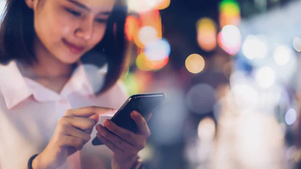 Closeup Woman Holding Smartphone Night City Shopping Street People Walk — Stock Photo, Image