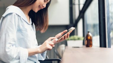 Boş zamanlarında akıllı telefon kullanan bir kadın. Telefonu kullanma konsepti günlük hayatta gereklidir..