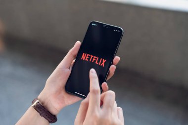Bangkok, Tayland - 12 Mart 2019: Kadınlar smartphone ekranında Netflix app kullanın. Netflix Tv olay ve film izlemek için bir uluslararası önemli abonelik hizmetidir.
