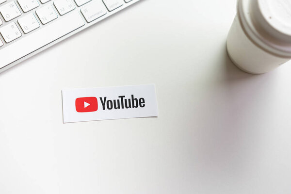 Bangkok, Thailand - March 12, 2019 : hand is pressing screen displays the Youtube app icons on paper label. YouTube is the popular online video-sharing website.