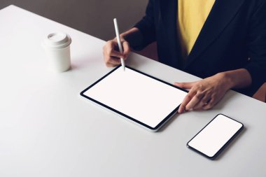 Tablet ekran boş ve smartphone masaya kadar sahte ürünlerinizi tanıtmak için kullanan kadın. Gelecek kavramı ve bilgilere kolay erişim için Internet eğilim.