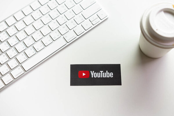 Bangkok, Thailand - May 6, 2019 : hand is pressing screen displays the Youtube app icons on paper label. YouTube is the popular online video-sharing website.