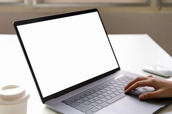 Woman using laptop on the table, mock up of blank screen.