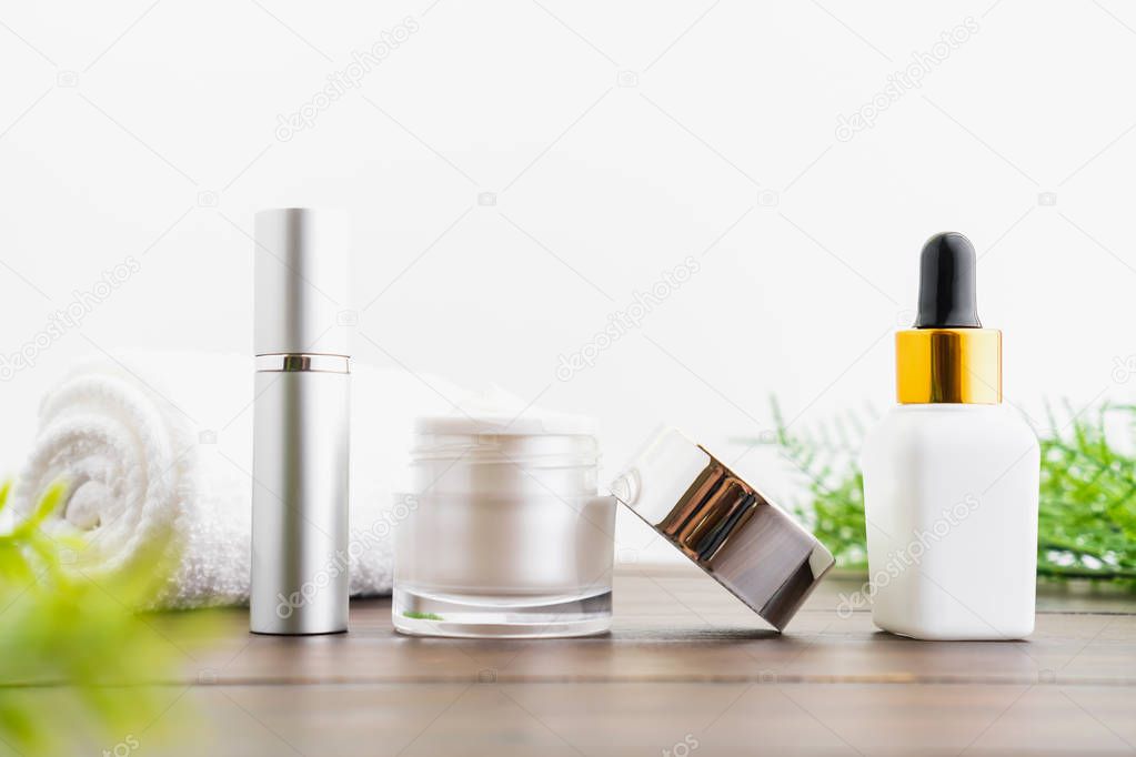 White serum bottle and cream jar, mockup of beauty product brand. Top view on the white background.