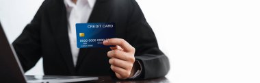 Online alışveriş ile kredi kartı ve dizüstü bilgisayar tutan iş kadını. Kolaylık sağlamak için çevrimiçi ödeme yapın