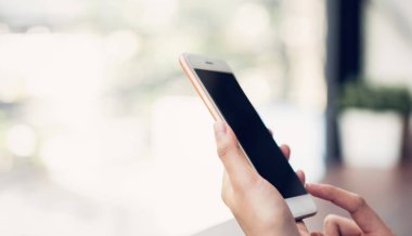 mutlu gülümsemek tutarak ve kafede akıllı telefon kullanarak kadınlar. Telefon kullanma kavramı günlük yaşamda esastır.