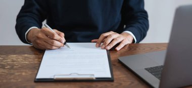 İşadamı finansal sözleşme imzalayarak ve el kalemi ile anlaşmaya vardıktan sonra imza atma.