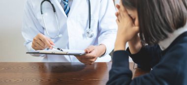 Yakın doktor hastaların belirtileri açıklamak, Sağlık ve tıbbi. ve hasta oturma dinlemek ve stres gösteren.