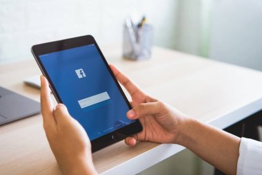 Bangkok, Tayland - 20 Ağustos 2019 : kadın el ele tutuşuyor ve apple dijital tabletfacebook ekranına basıyor , Sosyal medya bilgi paylaşımı ve ağ için kullanıyor.