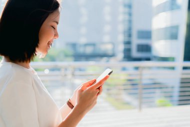 Boş zamanlarında akıllı telefon kullanan bir kadın. Telefonu kullanma konsepti günlük hayatta gereklidir..