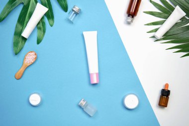 Mockup kozmetik krem şişesi, boş etiket paketi ve malzemelerin bir yeşil yaprakları arka plan üzerine. Doğal güzellik ürünleri kavramı.