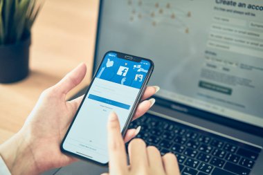 Bangkok, Tayland - 20 Ağustos 2019 : kadın el ele tutuşuyor ve apple akıllı telefonda Facebook ekranına basıyor, Sosyal medya bilgi paylaşımı ve ağ için kullanıyor.