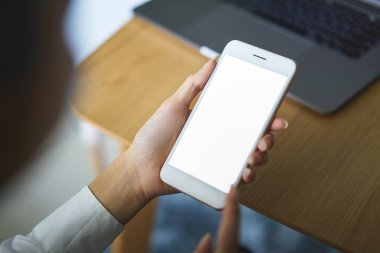 Kafede masada boş ekran lı el tutan akıllı telefon. Reklam vermek için ekranınızı alın.
