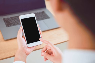 Kafede masada boş ekran lı el tutan akıllı telefon. Reklam vermek için ekranınızı alın.