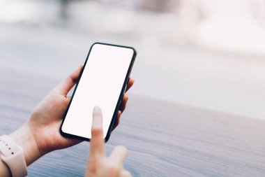 Bir smartphone tutan kadın closeup boş ekran alay. cep telefonu üzerinde kafe kullanarak. İletişim kavramı için teknoloji.