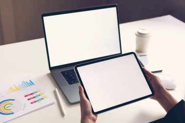 Ürünlerinizi tanıtmak için tablet ekran boş ve laptop masaya kadar sahte tutan kadın. Gelecek kavramı ve bilgilere kolay erişim için Internet eğilim.