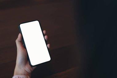 Bir smartphone tutan kadın closeup boş ekran alay. cep telefonu üzerinde kafe kullanarak. İletişim kavramı için teknoloji.
