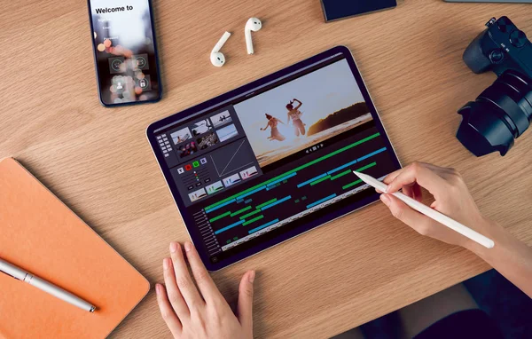 Blogger ve vlogger 'ın basit çalışması kavramı, video düzenleyicide dijital kalem kullanımı tablet, kamera ve masadaki aksesuarlarla çalışır.