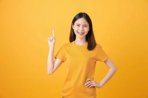 Sonriente Mujer Asiática Pie Señalando Dedo Sobre Fondo Naranja — Foto de Stock