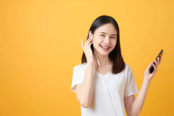Mujer Asiática Feliz Sosteniendo Smartphone Escuchando Música Sobre Fondo Rosa — Foto de Stock