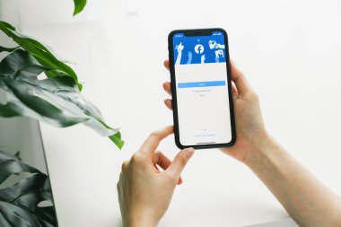 Bangkok, Tayland - 09 Ağustos 2020: Kadın eli Apple iphone 11 'de Facebook ekranına basıyor, Sosyal medya bilgi paylaşımı ve ağ paylaşımı için kullanıyor.